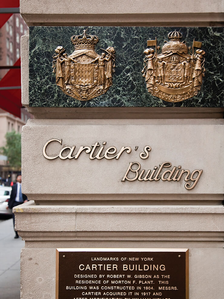 왕실 문장과 뉴욕 랜드마크 플레이트가 장식된 까르띠에 뉴욕 맨션의 벽.