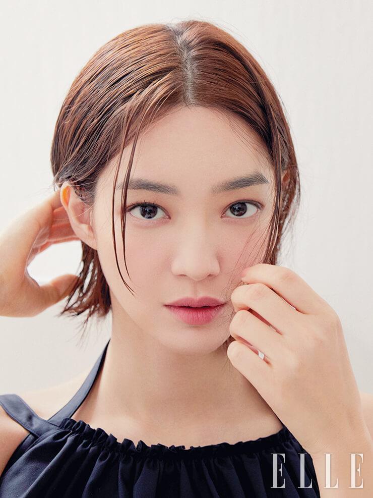 카메라를 응시하는 신민아의 그윽한 시선. 펄 없이 보송한 입자가 더욱 세련되고 모던하게 발리는 섀도 팔레트, 레 꺄트르 옹브르, 328 블러리 모브의 로즈우드와 토프 컬러를 믹스해 쌍꺼풀 라인 안쪽을 중심으로 바른다. 정교할 필요 없이 손끝으로 쓱쓱 펼쳐 바른 느낌. 차분한 분위기의 MLBB 립스틱인 루쥬 알뤼르 벨벳 엑스트렘 마뜨, 118 에떼넬을 톡톡 두드려 바른다. 사용 제품은 모두 Chanel.정교한 플리츠 디테일의 블랙 드레스는 Chanel.