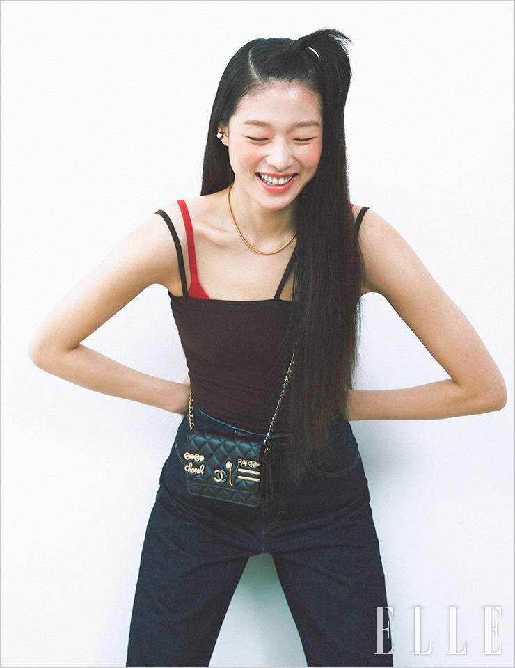 아라의 건강한 윤기 피부를 연출해 준 레 베쥬 젤 쿠션, Chanel. 다양한 참이 달린 베니티 백은 Chanel. 브라운 스트랩 탱크톱은 Baserange. 레드 브라톱은 스타일리스트 소장품. 딥 블루 데님 팬츠는 Levi’s. 메리 제인 슈즈는 Repetto.