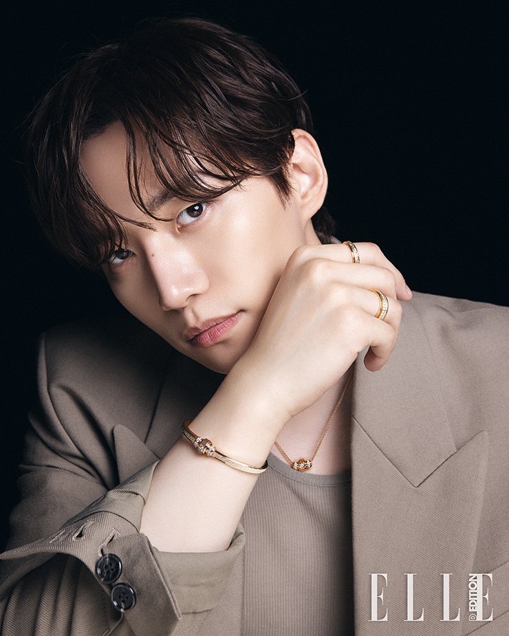 24개의 브릴리언트 컷 다이아몬드 (약 0.43캐럿) 와 1개의 브릴리언트 컷 다이아몬드 (약 0.09캐럿) 센터 스톤 세팅한 18K 핑크 골드 소재의 포제션 브레이슬릿, 오른 검지에 착용한 1개의 브릴리언트 컷 다이아몬드 (약 0.02 캐럿) 세팅한 18K 핑크 골드 소재의 포제션 링, 오른 약지에 착용한 1개의 브릴리언트 컷 다이아몬드(약 0.03캐럿) 센터 스톤 및 45개의 브릴리언트 컷 다이아몬드 세팅된 포제션 링, 총 25개의 브릴리언트 컷 다이아몬드 (약 0.52캐럿) 세팅한 18K 핑크 골드 소재의 포제션 펜던트는 모두 Piaget. 재킷과 이너 톱은 모두 Ami.