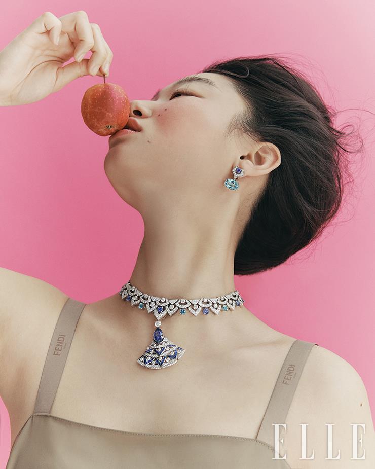 탄자나이트, 아쿠아마린, 사파이어 그리고 다이아몬드를 화려하게 장식한 디바스 드림 네크리스, 오벌 아쿠아마린, 라운드 탄자나이트 그리고 다이아몬드를 세팅한 이어링은 모두 Bulgari. 로고 스트랩 드레스는 Fendi.