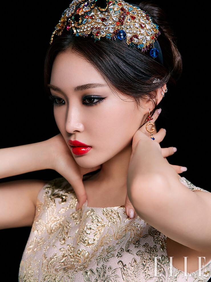 주얼 장식의 헤어피스, 골드 드레스, DG 로고 디테일의 이어링은 모두 DOLCE&GABBANA.