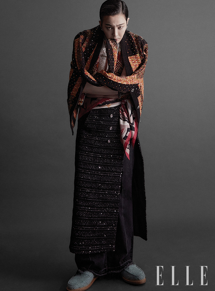 멀티컬러 카디건과 구슬 장식 실크 튤 베스트, 글리터드 트위드 스커트, 스트라스로 장식한 칼라 네크리스와 비브 네크리스, 허리에 묶은 스카프는 모두 Chanel.