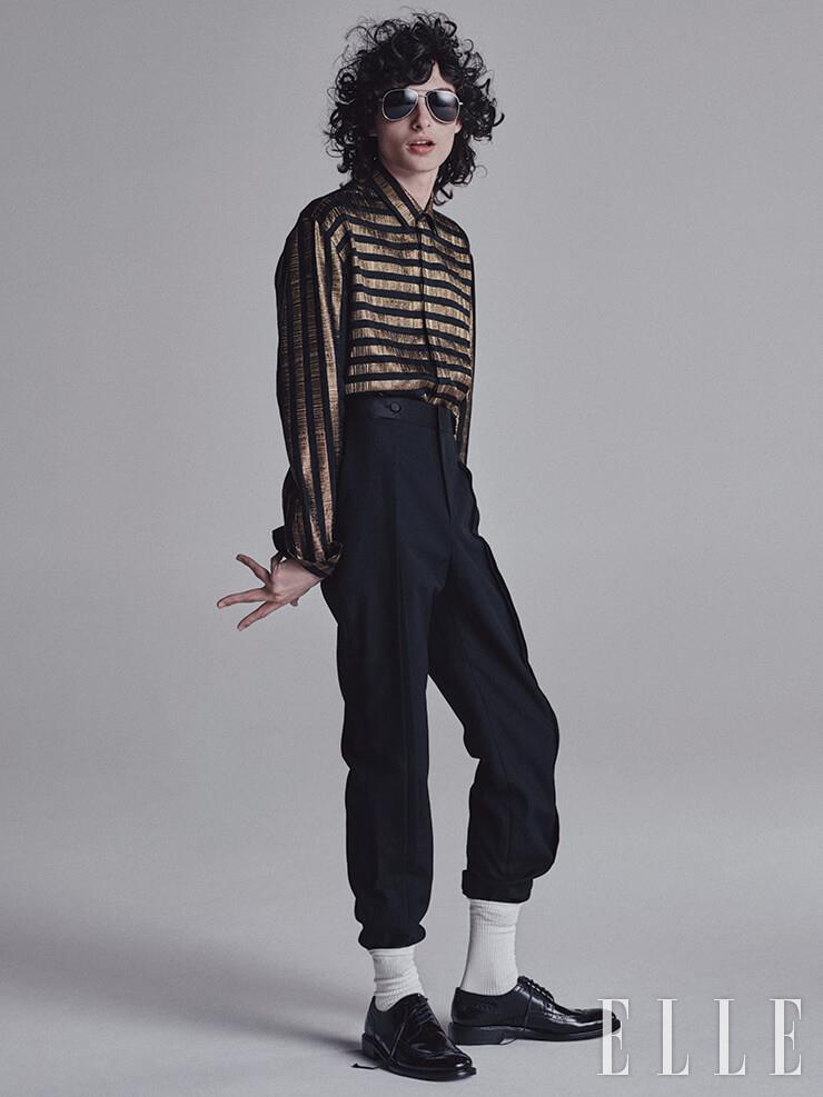 골드 스트라이프 셔츠와 더블 버튼 턱시도 팬츠, 더비 슈즈, 보잉 선글라스는 모두 Saint Laurent by Anthony Vaccarello. 