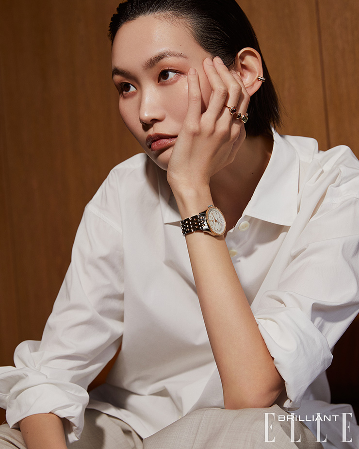 15개 라운드 다이아몬드를 세팅한‘콰트로 클래식 S 클립’ 이어 커프는 3백만원대 BOUCHERON. 검지와 중지에 레이어드로 착용한 ‘메테오르’ 링은 가격 미정 HERMÈS. 18K 레드 골드와 스틸의 조화가 돋보이는 ‘내비타이머 오토매틱 35’ 워치는 1천2백만원대 BREITLING. 화이트 세라믹 ‘비제로원’ 브레이슬릿은 9백50만원대 BULGARI. 화이트 셔츠는 스타일리스트 소장품. 팬츠는 20만원대 COS.