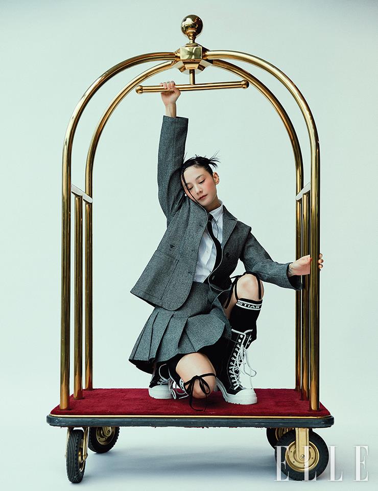 그레이 재킷과 셔츠, 타이, 그레이 플리츠스커트, 바이커 쇼츠, 블랙 삭스, 슈즈 모두 Dior.