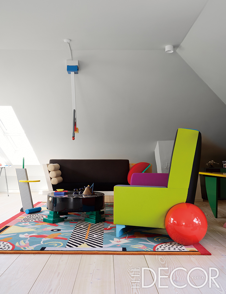 나탈리 뒤 파스키에(Nathalie du Pasquier)가 디자인한 러그 ‘리비에라(Riviera)’를 비롯한 모든 인테리어 제품이 멤피스 밀라노에서 제작됐다. 미국 디자이너이자 예술가인 피터 샤이어의 ‘빅 수르(Big Sur)’ 소파와 ‘벨 에어(Bel Air)’ 안락의자가 러그 위에 놓여 그래픽 디자인의 묘미를 잘 살려준다. 커피 테이블 ‘파크 레인(Park Lane)’과 ‘퀴시사나(Quisisana)’ 펜던트 조명은 에토레 소트사스의 디자인.