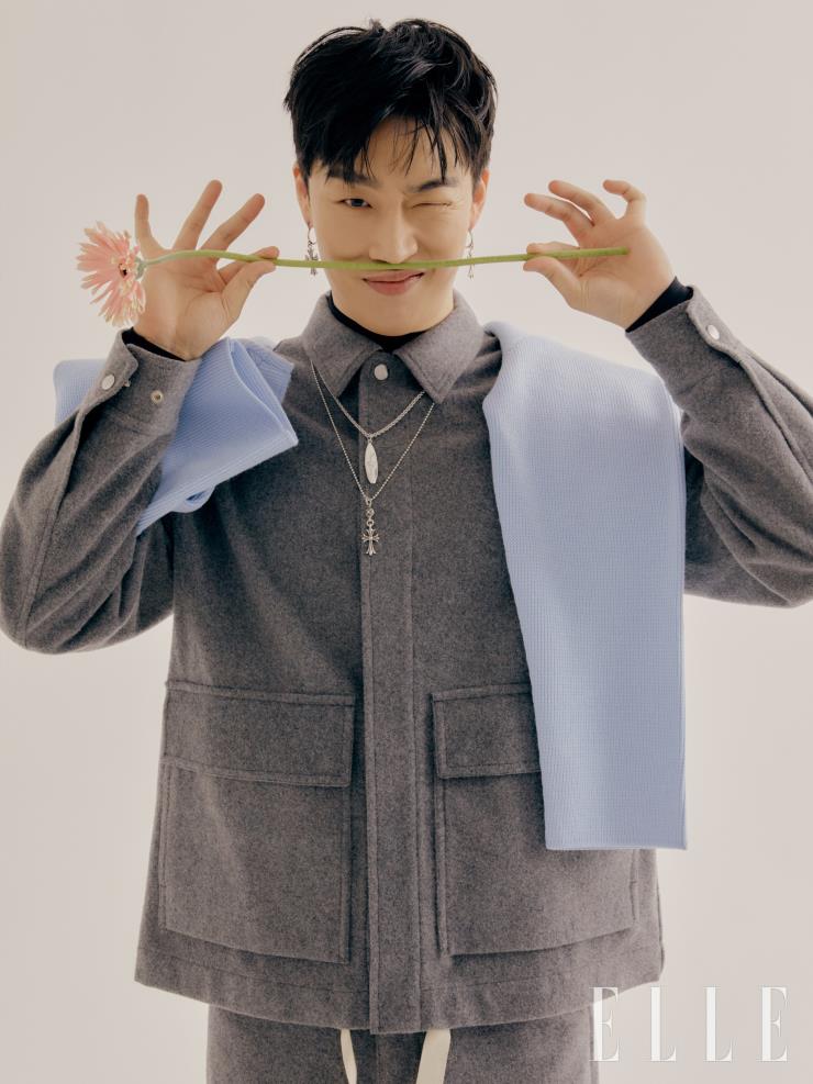 멜란지 소재 그레이 재킷과 팬츠 모두 Jil Sander. 어깨에 걸친 니트 톱은 Av Vattev by BOONTHESHOP. 서핑 보드 모티프의 네크리스는 Dior Men. 펜던트 네크리스와 이어링 모두 Chrome Hearts.