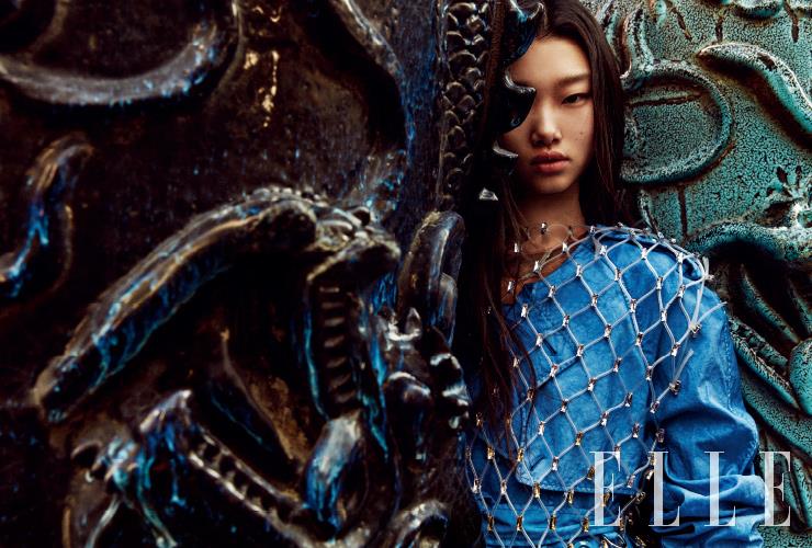 블루 컬러의 테크니컬 트렌치코트와 보디수트, 주얼 장식의 네트 톱은 모두 Burberry.