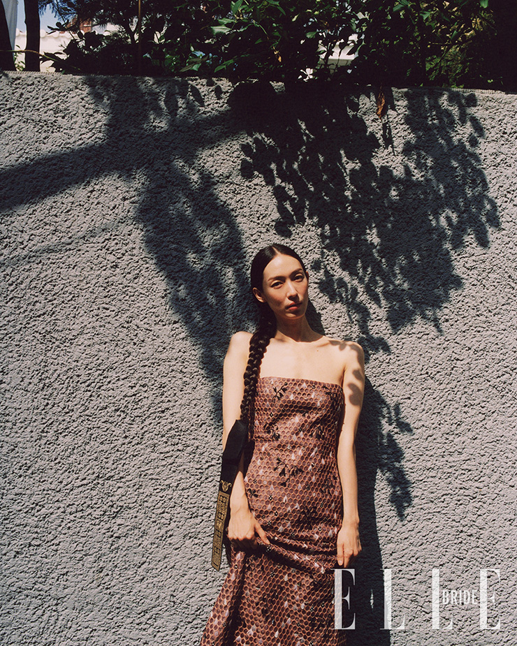섬세한 깃털 장식 원피스는 Jaden Cho. 보라색 댕기 장식은 Yunui Hanbok.