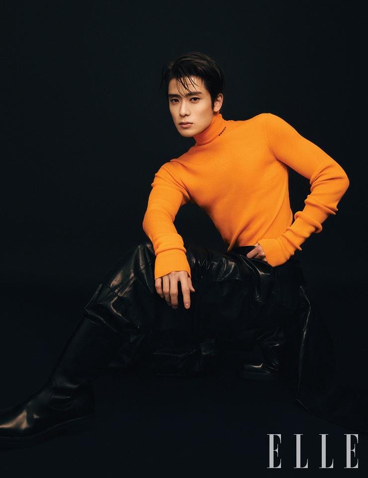 비비드한 오렌지 컬러의 폴로 니트 톱과 레더 팬츠, 블랙 부츠는 모두 Prada.