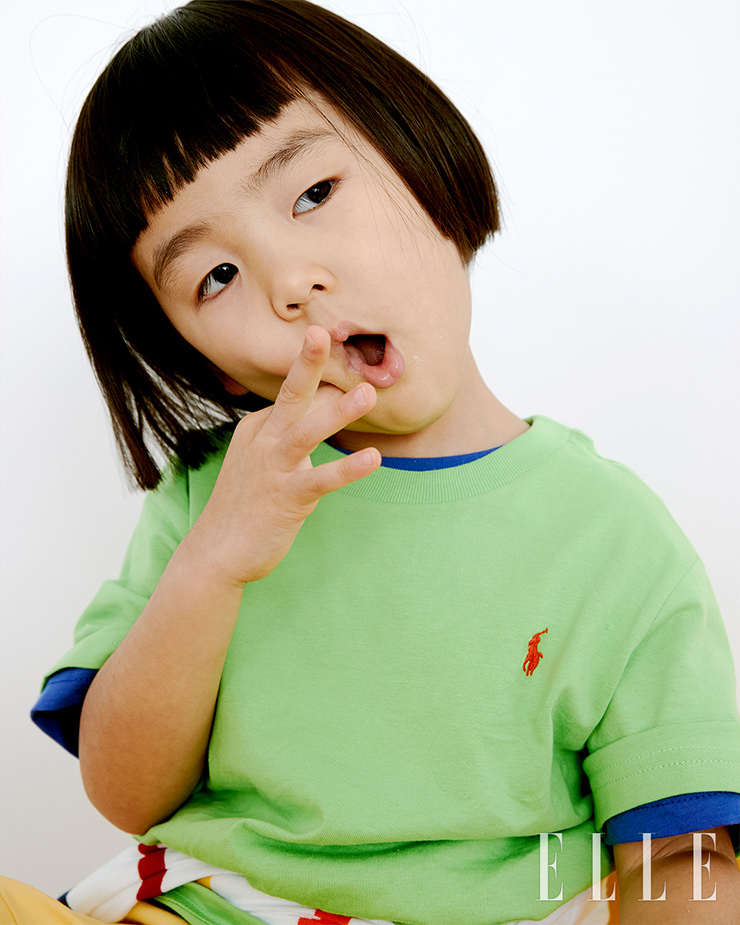이준이 입은 그린 코튼 저지 크루넥 티, 레이어드한 블루 크루넥 티,허리에 두른 스트라이프 코튼 저지 럭비 셔츠, 옐로 컬러 코튼 쇼츠는 모두 Polo Ralph Lauren.