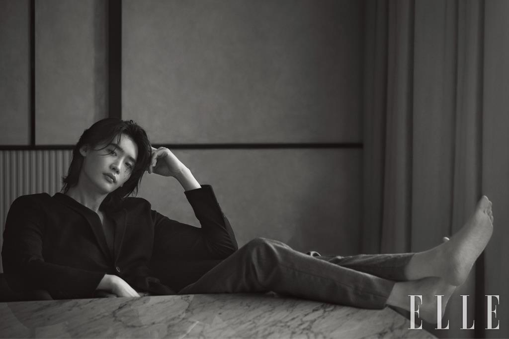 블랙 재킷과 그레이 팬츠는 모두 Prada.