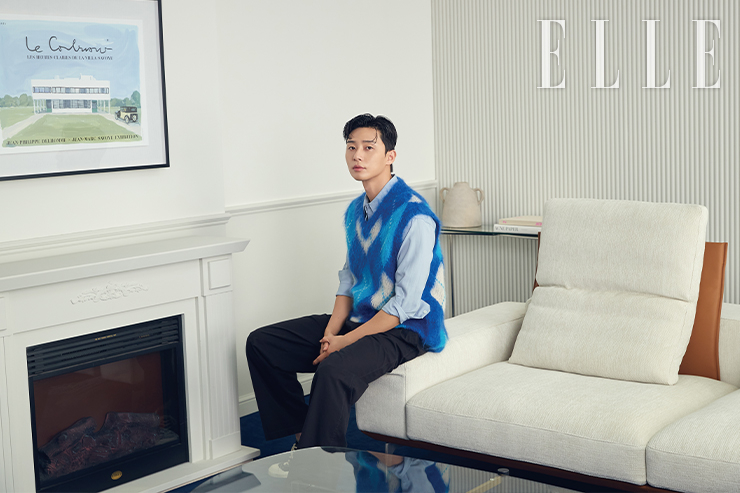 유럽산 하이엔드 직조 패브릭 비에스테와 가죽 콤비로 디자인한 4인 카우치형 소파. 전체적으로 넓고 슬림한 디자인으로 모던하고 럭셔리한 분위기를 연출한다. 이동이 가능한 백 레스트 기능을 갖추었으며, 좌방석에 에어리폼, 등방석에는 구스가 내장되어 안락한 착석감을 선사한다. 트레비 4인 카우치형 비에스테 패브릭 소파 Essa. 니트 베스트는 Marni by MUE, 팬츠는 The Row, 셔츠는 스타일리스트 소장품.