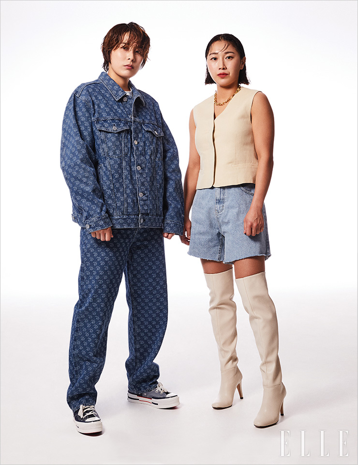 성연이 입은 데님 세트업은 H&M. 하이톱 스니커즈는 Converse. 안에 입은 티셔츠는 스타일리스트 소장품. 희정이 입은 슬리브리스 베스트와 네크리스는 모두 COS. 하프 데님 팬츠는 Moont. 사이하이 부츠는 스타일리스트 소장품. 