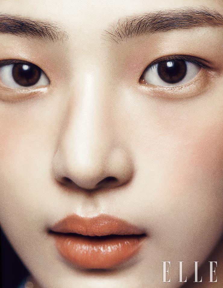 솜털까지 예쁜 민지의 피부에 N°1 DE CHANEL 레드 까멜리아 파운데이션을 얇게 펴 바른다. 레 베쥬 워터-프레시 블러셔, 라이트 피치를 손끝에 묻혀 양볼과 콧등, 눈 앞머리까지 가볍게 터치한 뒤, 레 베쥬 헬시 글로우 내추럴 아이섀도우 팔레트, 웜에 든 은은한 샴페인 골드 섀도로 시어한 질감을 더한다. 루쥬 코코 밤, 916 플러티 코랄을 입술에 가득 메워 발라 생기 넘치는 톤 온 톤 메이크업 완성. 사용 제품은 모두 Chanel.