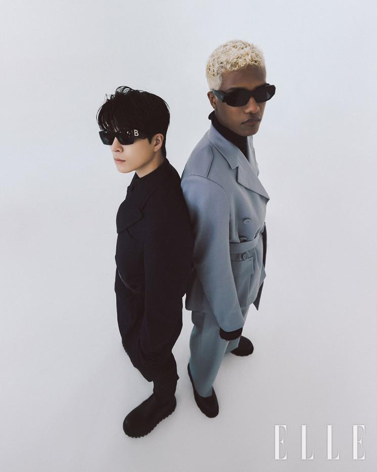 현민이 입은 그레이 셋업 수트는 Dior Men. 터틀넥 톱은 스타일리스트 소장품.  부츠는 Emporio Armani. 선글라스는 Prada by Luxottica. 영재가 입은 버클 디테일의 셋업 수트와 셔츠, 퍼 앵클 부츠는 Dolce&Gabbana. 벨트는 모두 Saint Laurent by Anthony Vaccarello. 선글라스는 Burberry by Luxottica.