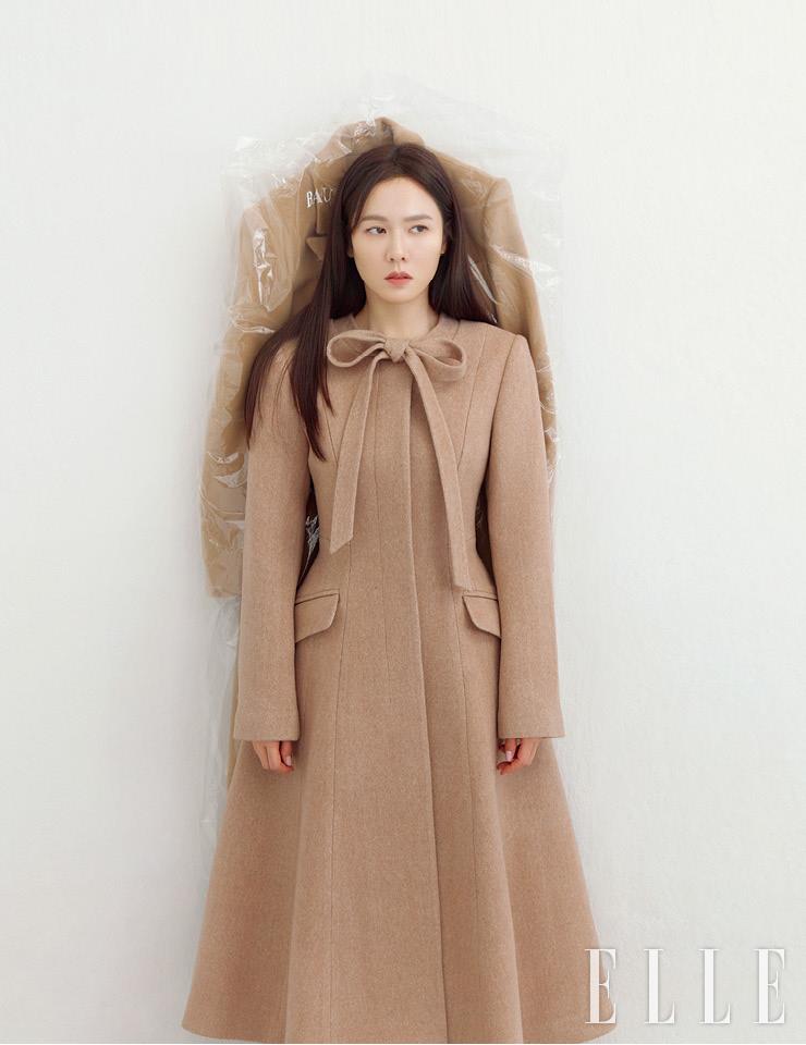 라운드 네크라인에 부착된 타이 디테일이 여성스러운 A라인 원피스 코트는 BAU by Bride and You.