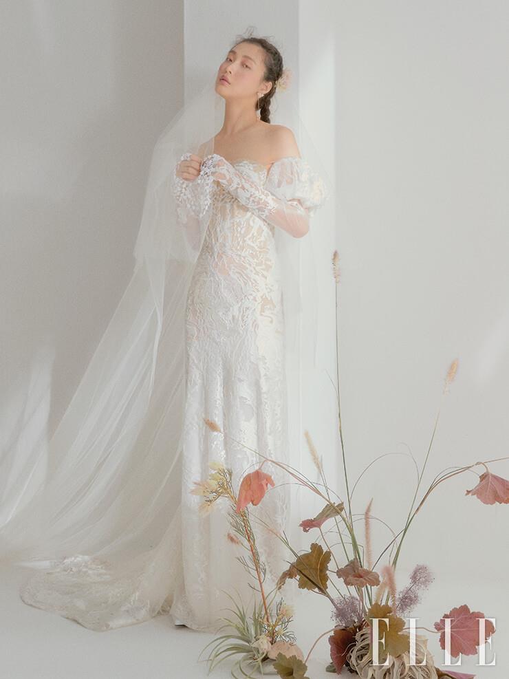 전체적인 실루엣이 고급스러운 레이스 드레스는 Inbal Dror by Atelier Ku. 롱 베일은 Atelier Ku. 이어링은 Atelier Swarovski.