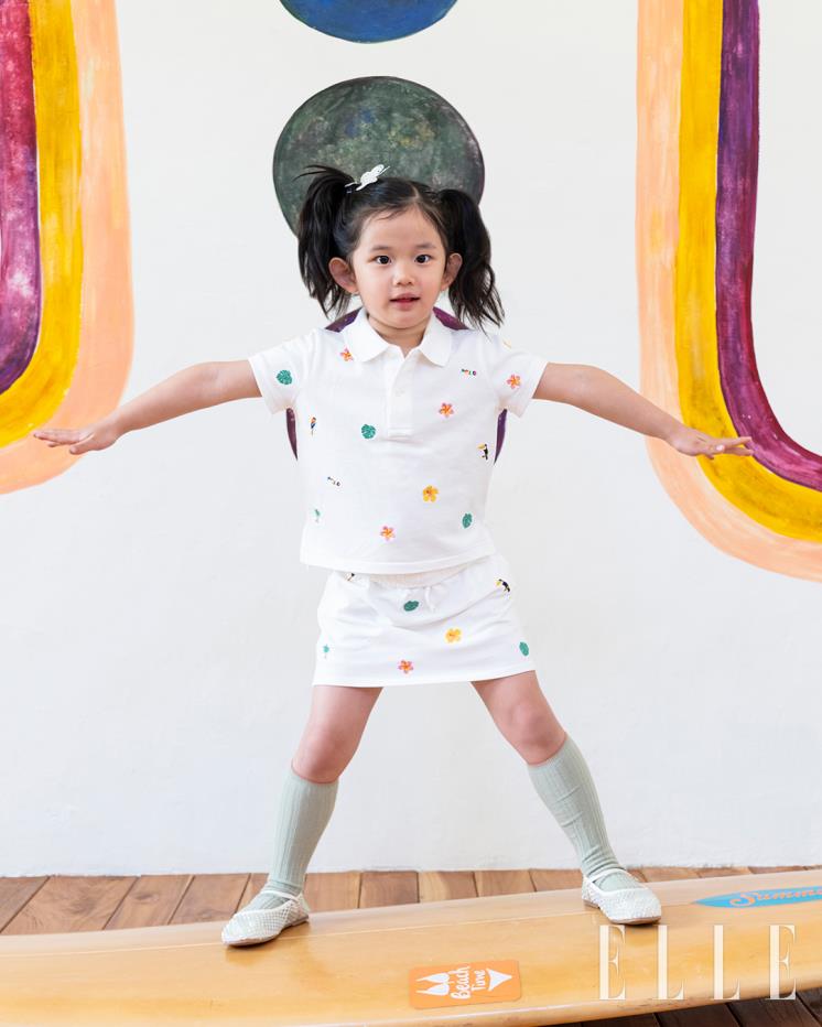 트로피컬 무드의 자수가 들어간 메시 소재 폴로 셔츠와 스커트는 모두  Polo Ralph Lauren Children.