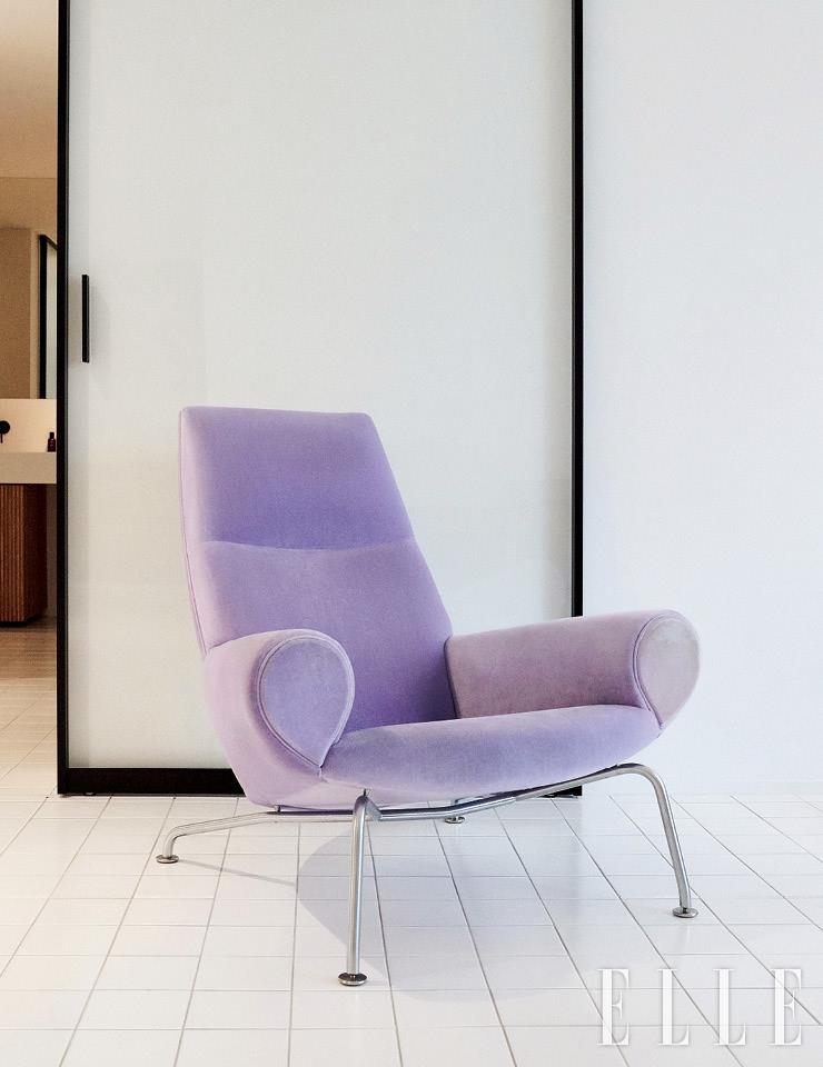 연보라색 소파가 하얀 공간에 색감을 더한다. 암체어는 Erik Joergensen.