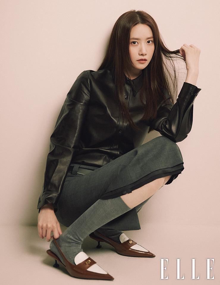 블랙 레더 셔츠와 그레이 스커트, 벨트, 그레이 삭스, 포인티드 토 슈즈는 모두 Miu Miu.