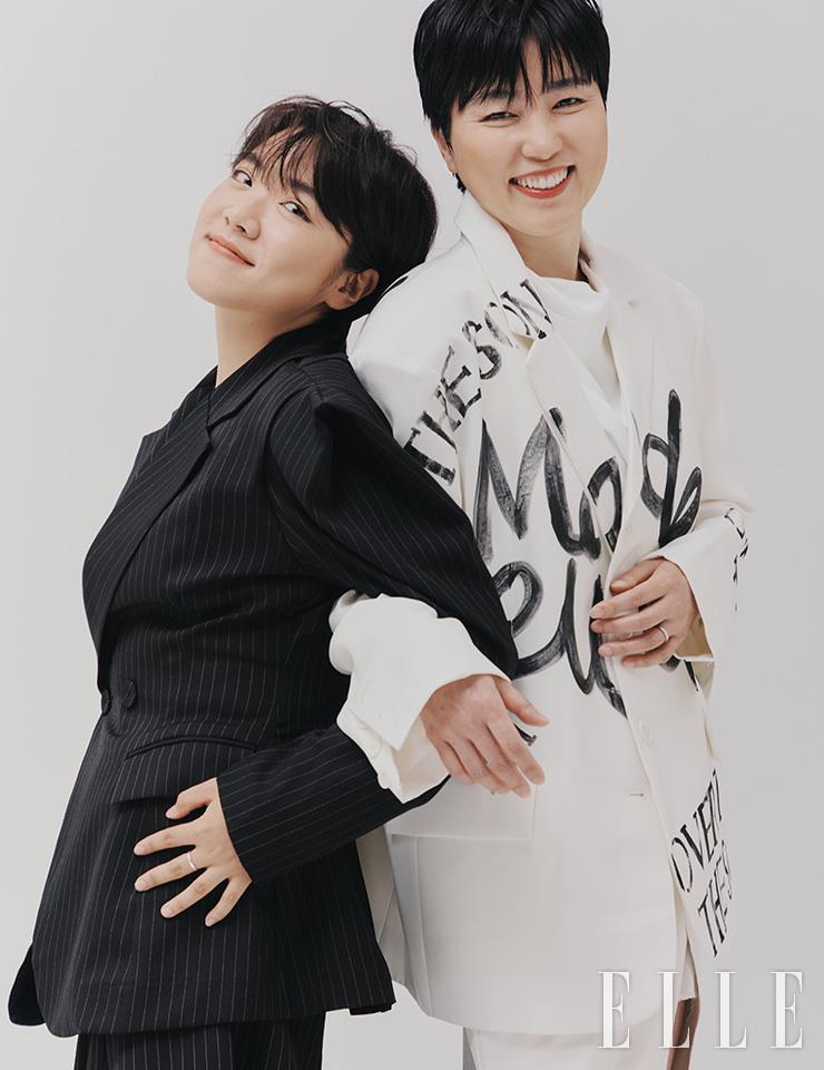 김수정이 입은 수트 세트업은 Dint. 슬리브리스 톱은 Whole Paper. 권미경이 입은 레터링 싱글 재킷과 블라우스, 미디스커트는 모두 Dint.