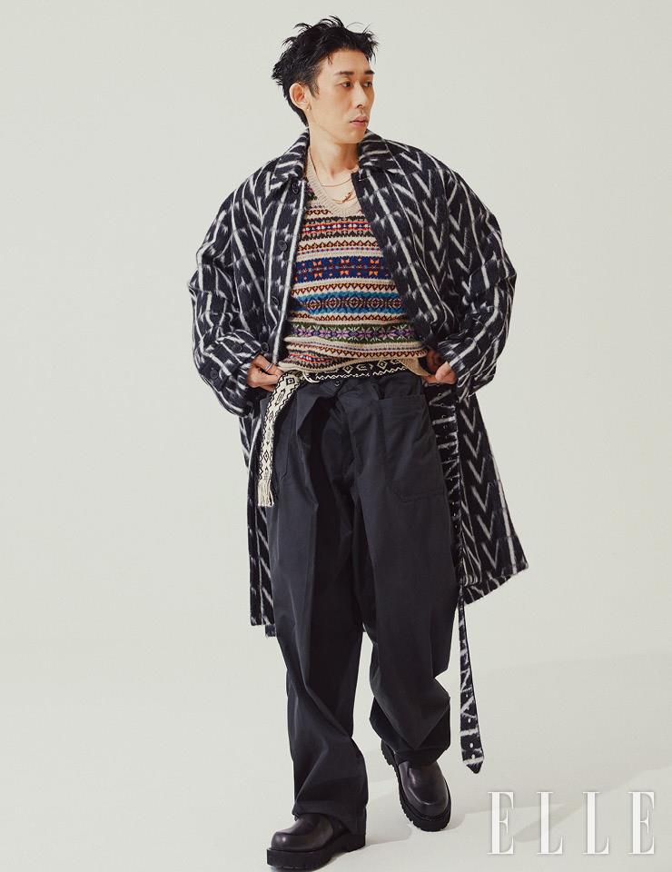 로고 패턴의 코트는 Valentino. 니트 베스트는 Polo Ralph Lauren. 앵클부츠는 Valentino Garavani. 잭 드 부쉐론 네크리스와 검지에 착용한 블루 에디션 콰트로 링은 모두 Boucheron. 벨트는 Isabel Marant Homme. 와이드 팬츠는 본인 소장품.