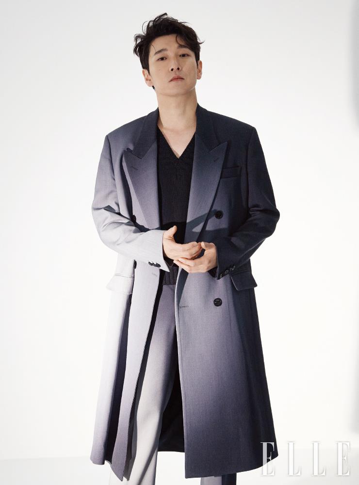블랙 니트 베스트와 더블 스포트라이트 프린트의 롱 코트, 슬림 핏 팬츠는 모두 Fendi.