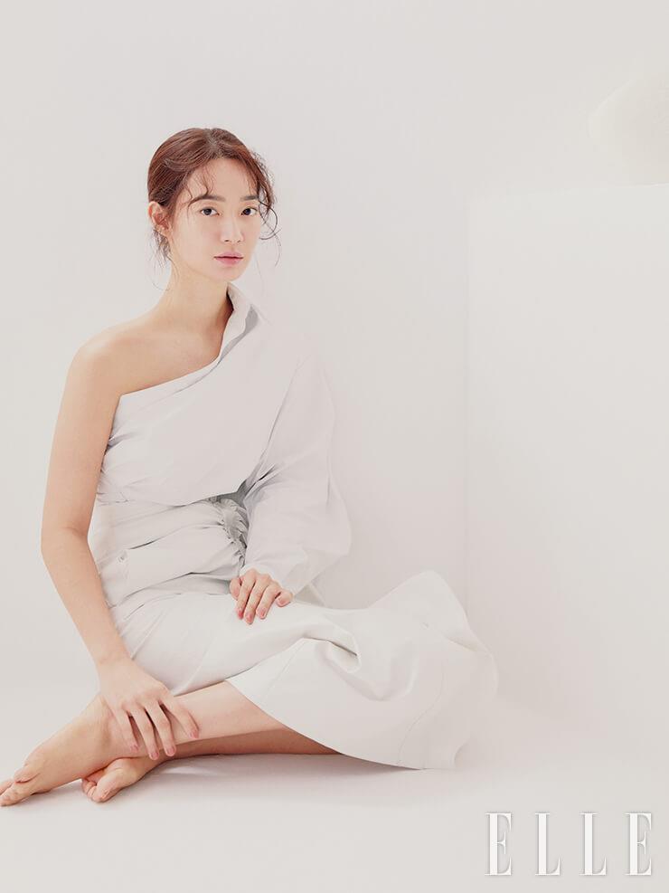  섬세한 진줏빛 펄감이 도는 이드라 뷰티 까멜리아 워터 크림을 발라 피부 표면에 담백한 윤기를 표현한 뒤, 르 블랑 메이크업 베이스, 로제를 발라 피부 톤을 화사하게 연출한다. 속부터 배어나는 듯한 혈색을 부여하기 위해 쥬 꽁뜨라스뜨, 44 나르시스를 양 볼에 가볍게 바르고, 사랑스러운 핑크빛의 루쥬 코코 플래쉬, 72 러쉬를 입술에 발라 마무리. 사용 제품은 모두 Chanel. 원 숄더 톱과 스커트는 Max Mara.