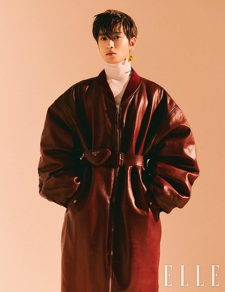 오버사이즈의 벨티드 레더 코트와 화이트 터틀넥 톱, 로봇 모티프의 이어링은 모두 Prada.