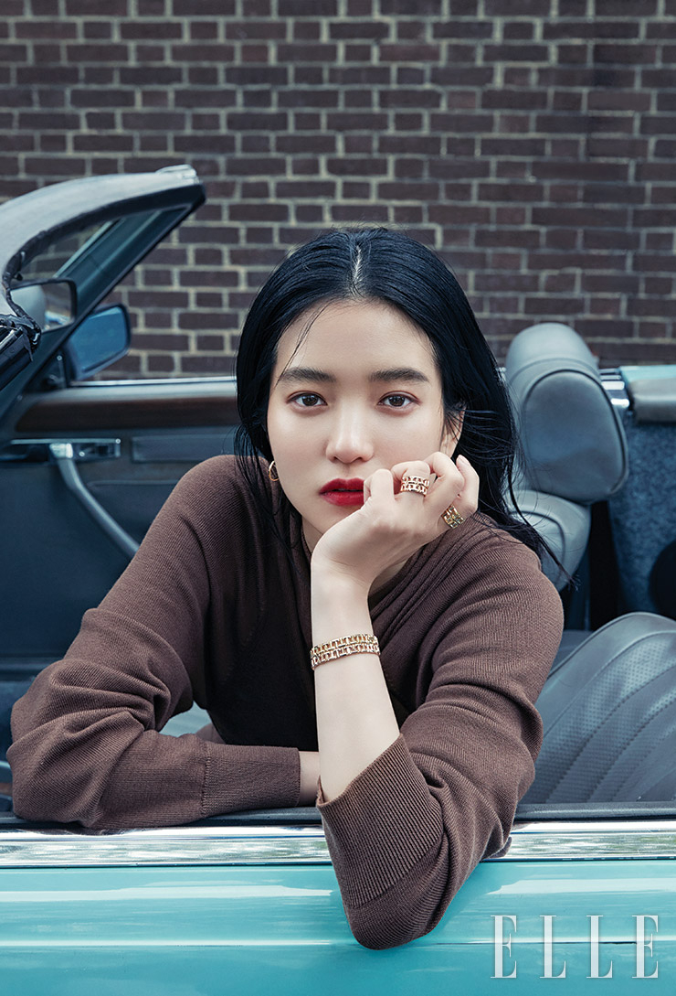 알파벳 T가 체인 형태로 교차된 옐로와 로즈골드 소재의 티파니 T 트루 와이드 링, 건축적인 디자인의 티파니 T 트루 내로 브레이슬렛, 옐로골드 티파니 T 와이어 후프 이어링은 모두 Tiffany & Co. 랩 스타일의 니트 카디건은 Ports 1961.