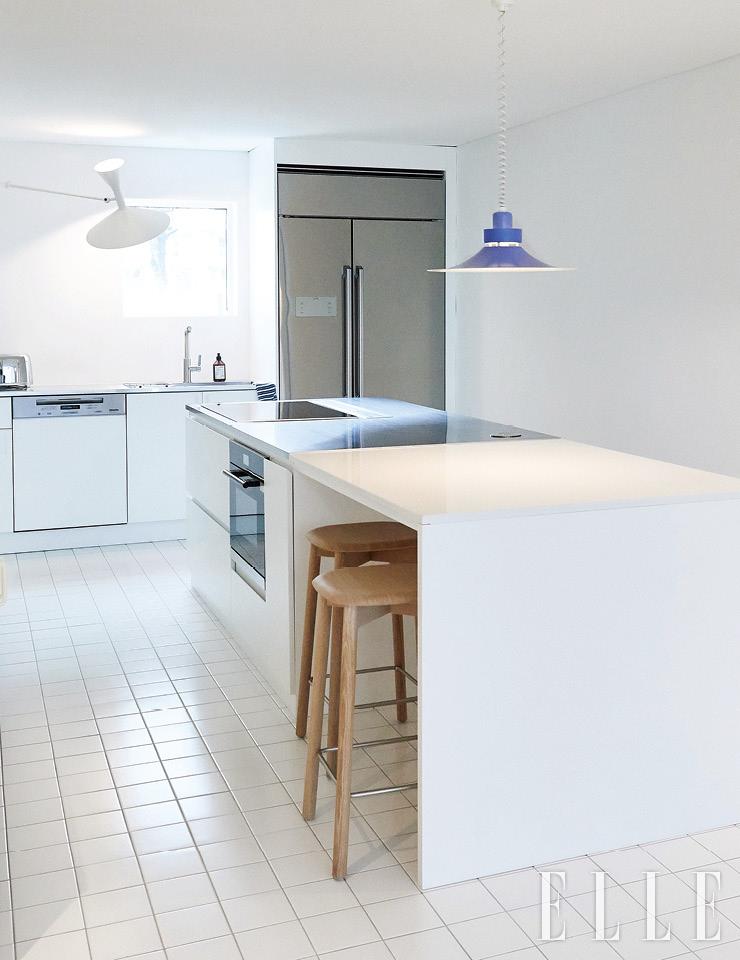 우드와 세라믹, 스테인리스스틸의 세 가지 소재가 조화롭게 어우러지는 주방. 조명은 빈티지 제품.