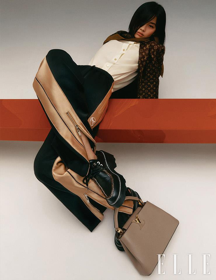 담백한 가렛 컬러의 ‘카퓌신BB’ 백, 네크라인에 스카프가 장식된 블라우스와 모노그램 패턴의 재킷, 조거 팬츠, 더비 슈즈는 모두 Louis Vuitton.